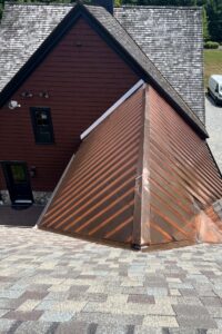 Custom copper standing seam shed dormer on a cedar shake home in Massachusetts, fabricated and installed by Paul John & Son