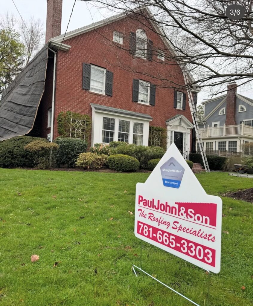 Paul John & Son Roofing yard sign with CertainTeed SELECT ShingleMaster badge in the foreground of an active roof installation on a brick Colonial Revival home in Greater Boston, MA. Roof is tarped for weather protection during install.